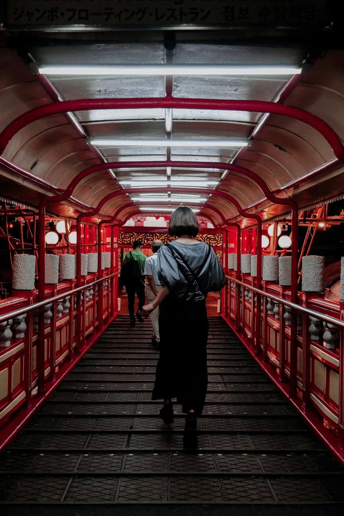 A woman walking through a red covered walkway