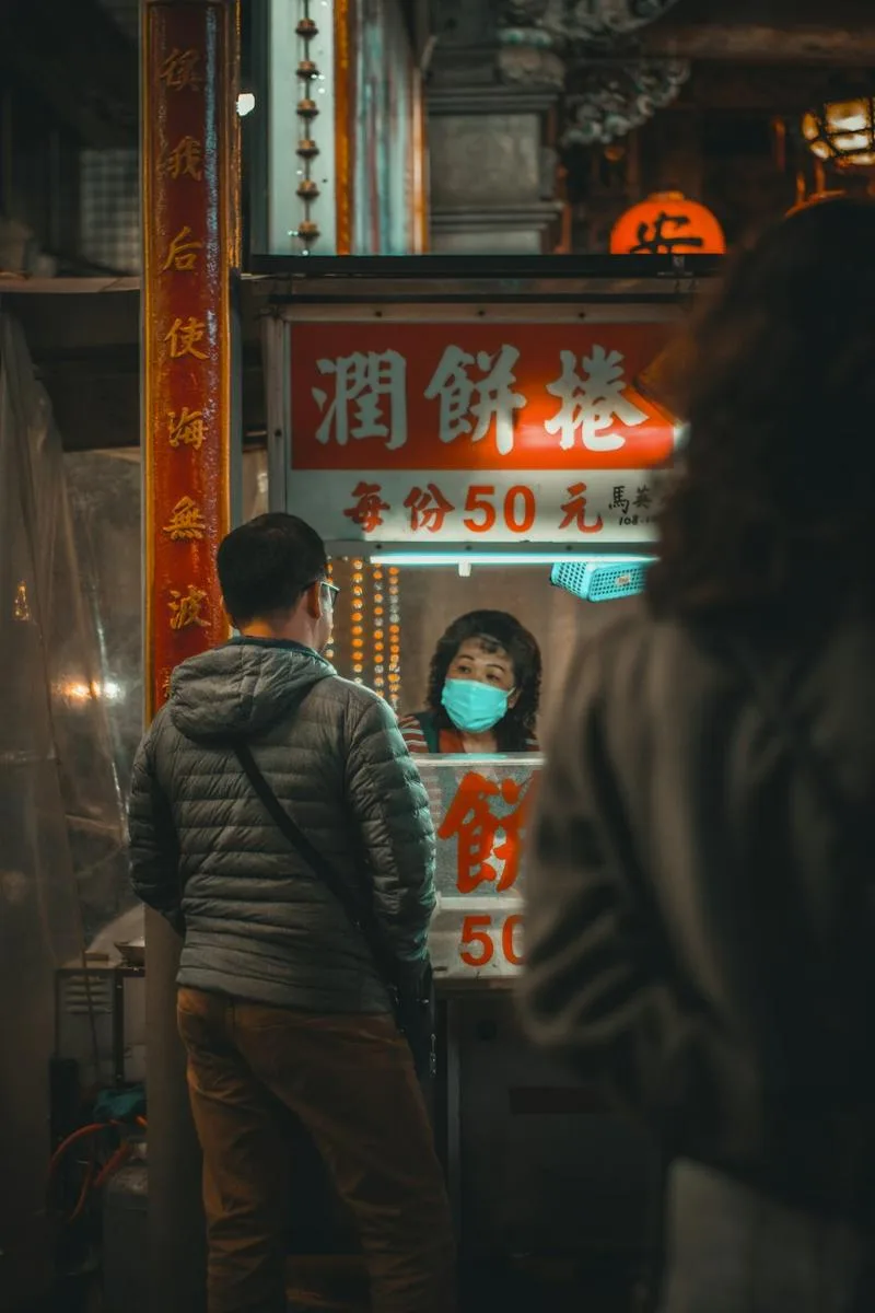 Queueing at a stall under its glowing sign