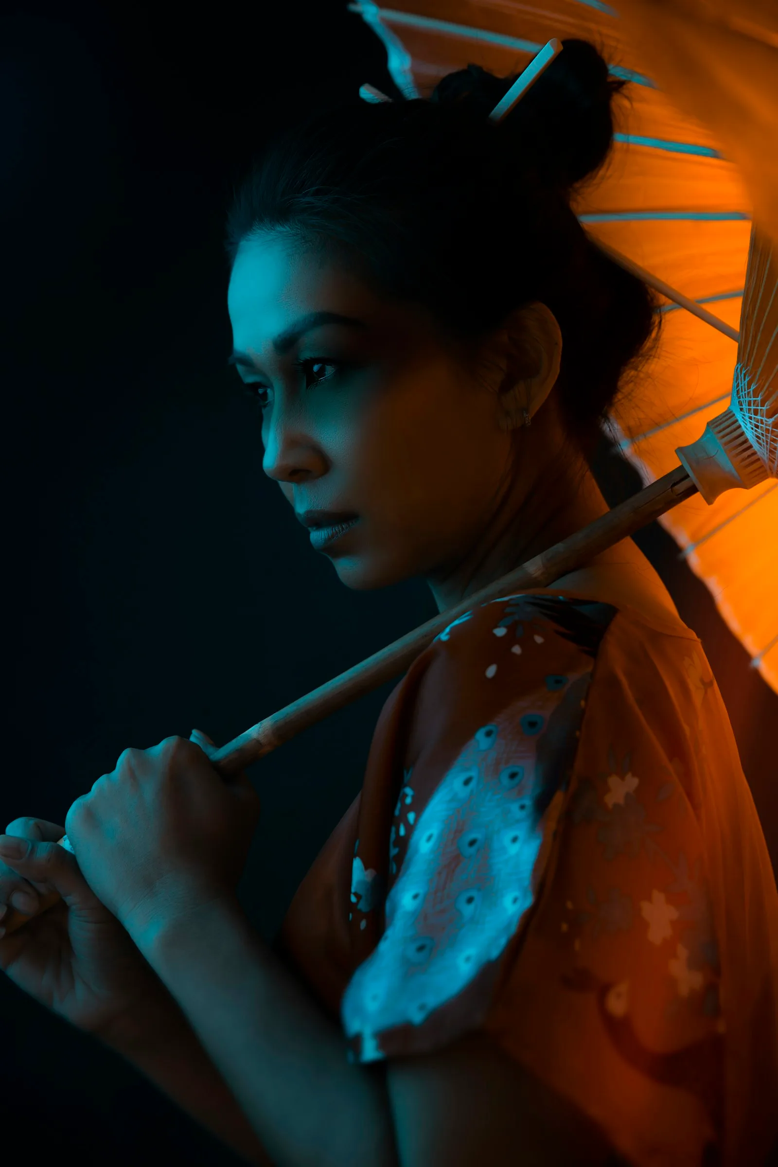 A woman with an umbrella under orange neon